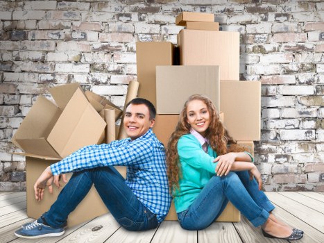 Professional movers carrying furniture through a managed building entrance